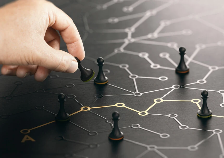 Ręka ustawiająca pionek szachowy na siatce połączonych węzłów — ilustracja strategii omnichannel i punktów styku z klientem