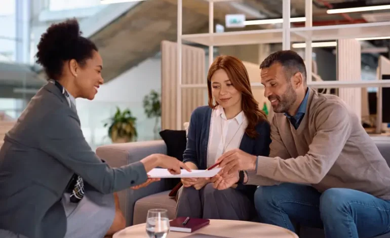Doradczyni finansowa omawia warunki kredytowe z parą klientów w nowoczesnym biurze