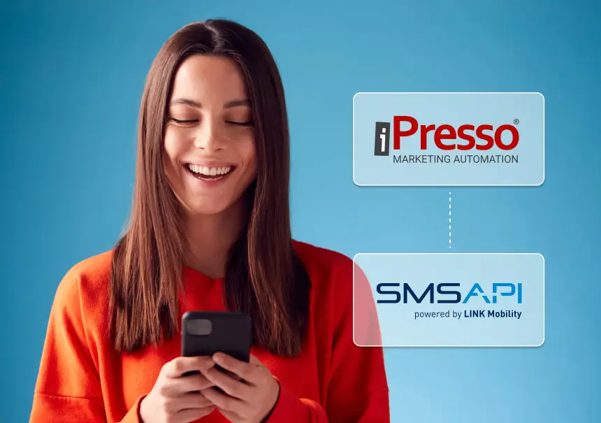 Kobieta uśmiecha się patrząc w telefon – integracja iPresso Marketing Automation z SMSAPI umożliwia automatyczne wysyłanie SMS w kampaniach marketingowych.